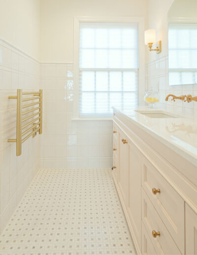 Spacious master bathroom featuring a double vanity with brass fixtures, white cabinetry, and bright natural light in a Rosemont, NJ remodel.