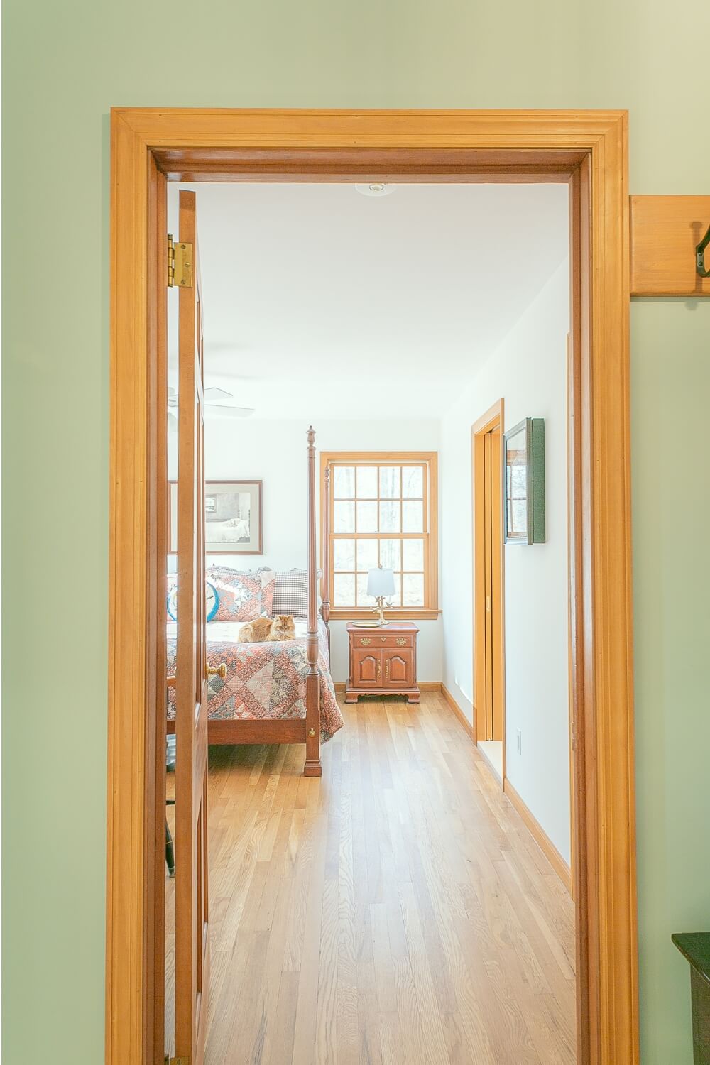 Bedroom view through a hallway door with natural wood trim