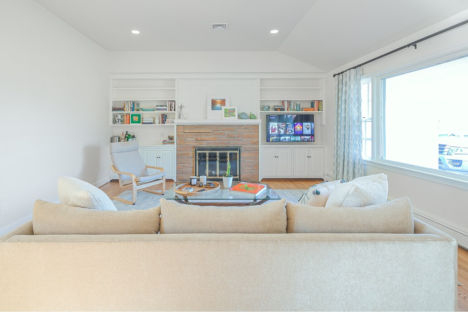 Bright living room remodel with built-in shelves and stone fireplace in Rosemont, NJ