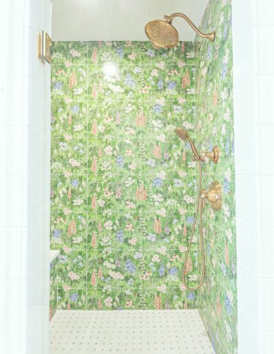 Shower wall with floral tiles and brass fixtures