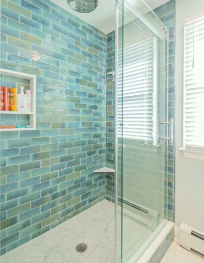 Glass shower with aqua blue subway tile and modern fixtures in Rosemont bathroom remodeling project