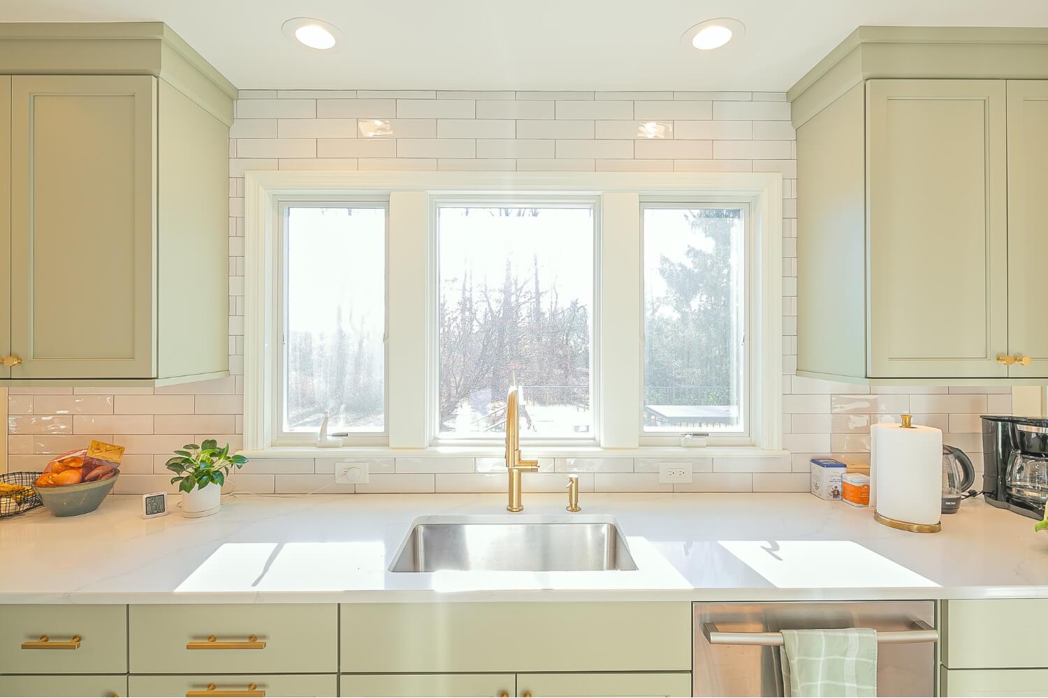 Kitchen sink with brass fixtures and white subway tile backsplash in Rosemont, NJ remodel.