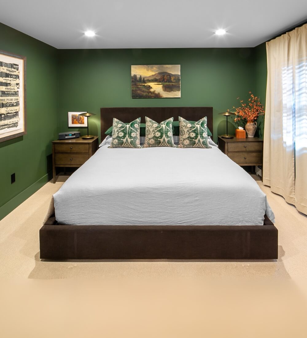 Beautifully designed master bedroom with green walls, elegant decor, and modern furniture.