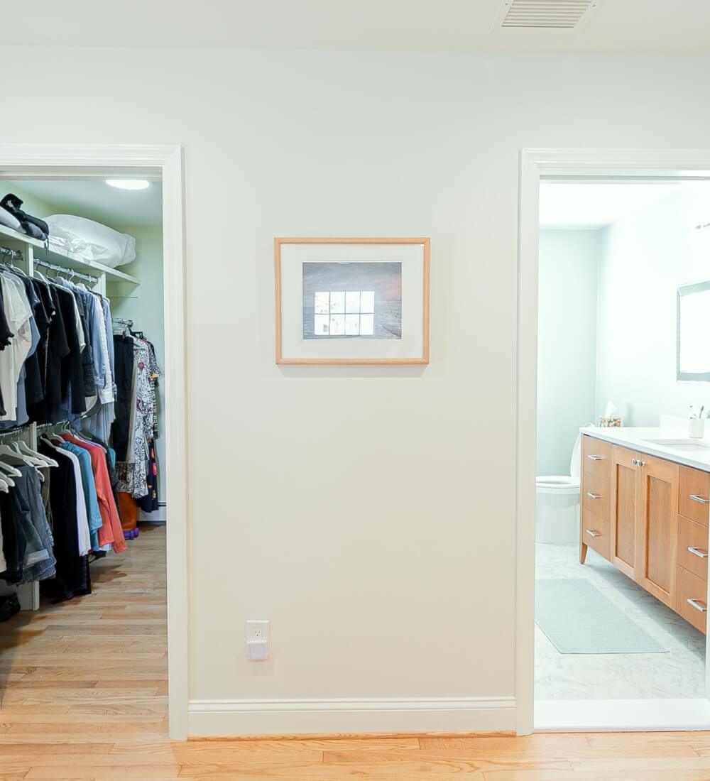 Walk-in closet adjacent to a master suite bathroom featuring organized storage and sleek design.