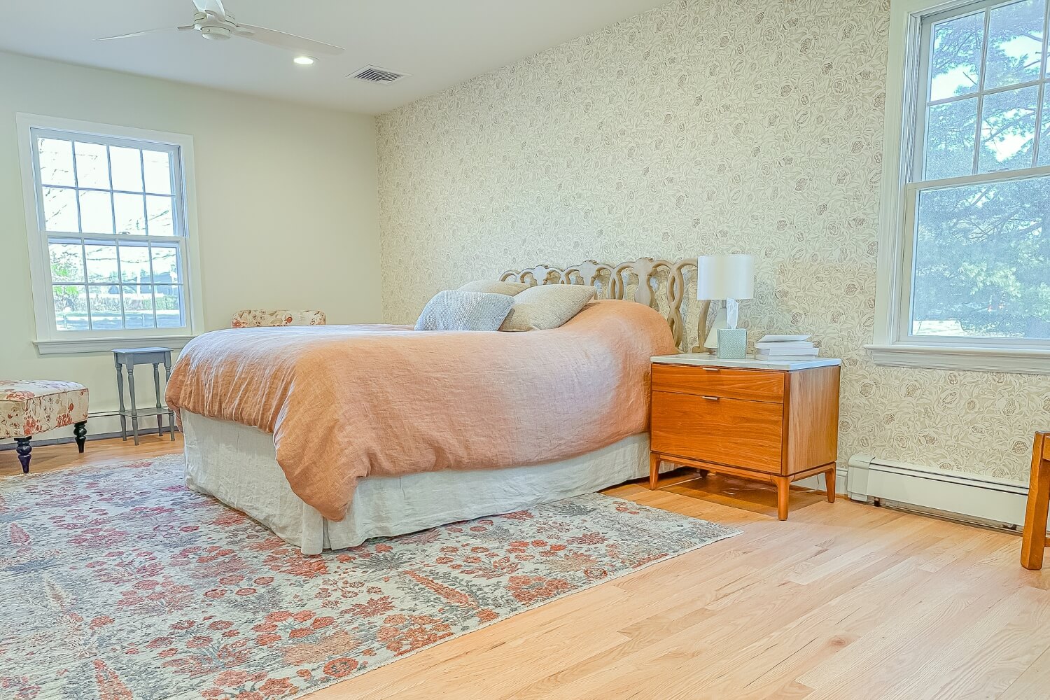 Primary bedroom with floral wallpaper and vintage furnishings in Rosemont, NJ remodel.