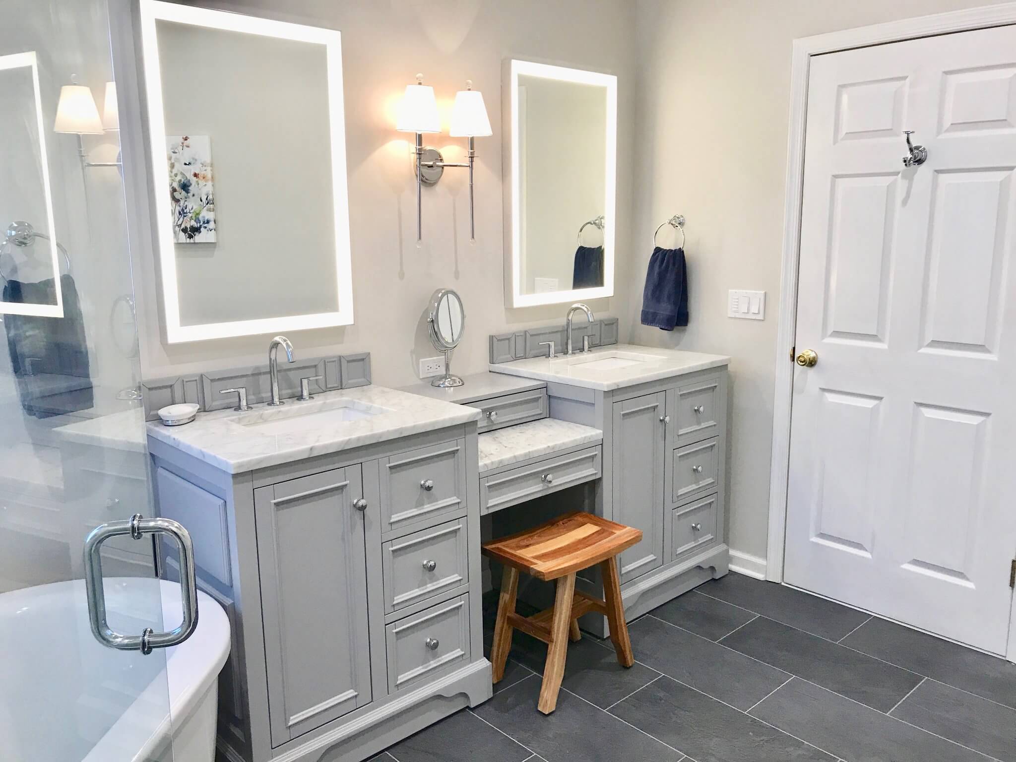 Double vanity with LED mirrors and stylish gray cabinetry.